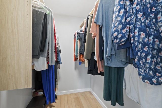 walk in closet with wood finished floors