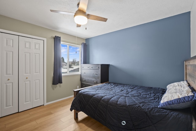 bedroom with a textured ceiling, wood finished floors, a ceiling fan, and baseboards