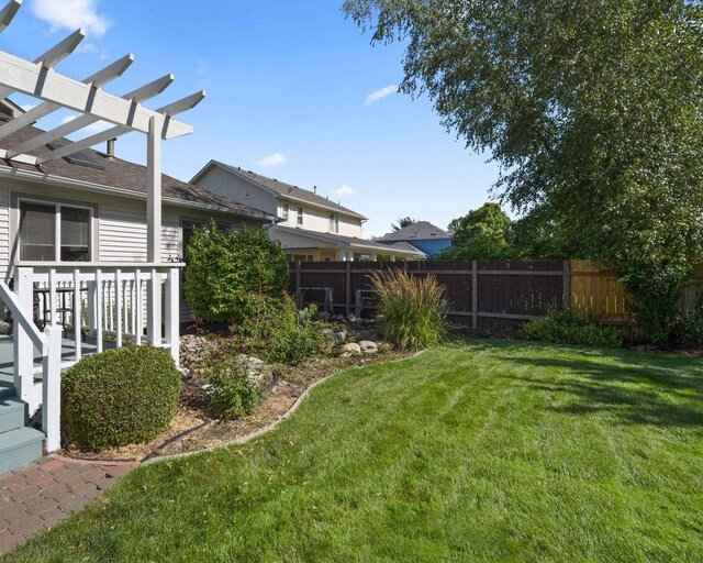 view of yard featuring fence and a pergola