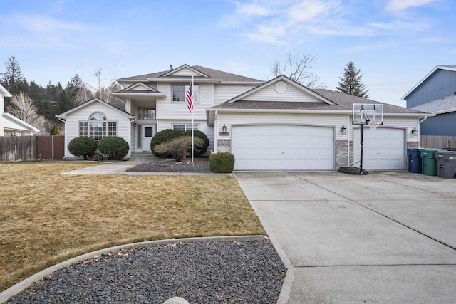 traditional-style home with a front yard, driveway, an attached garage, and fence