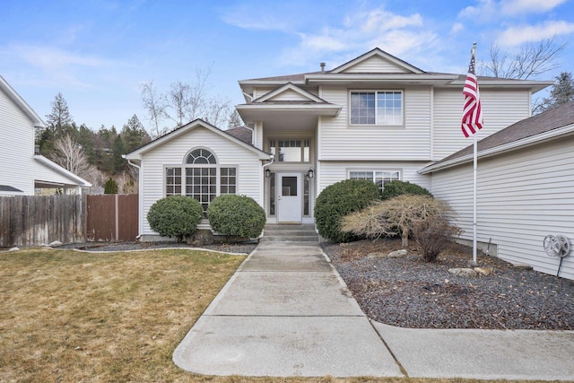 traditional-style home with fence and a front lawn