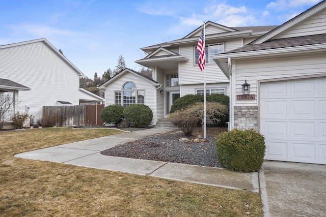 traditional-style home with a garage, a front yard, and fence