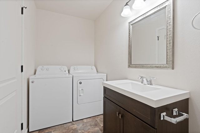 laundry room with a sink, laundry area, stone finish flooring, and washer and dryer