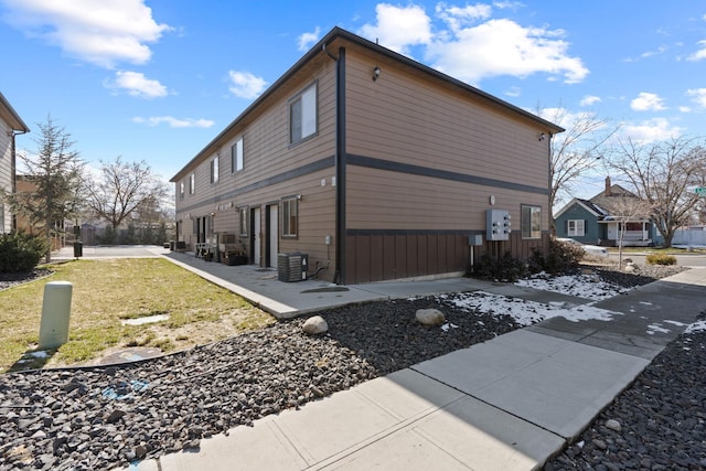 view of side of home featuring a lawn and central air condition unit