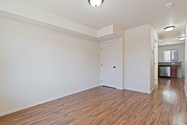 spare room featuring wood finished floors and baseboards