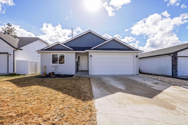 ranch-style home with a garage, fence, a front lawn, and concrete driveway