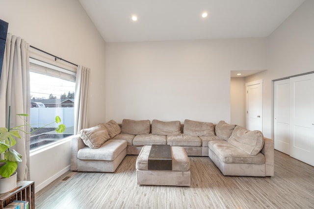 living area with high vaulted ceiling, recessed lighting, baseboards, and wood finished floors