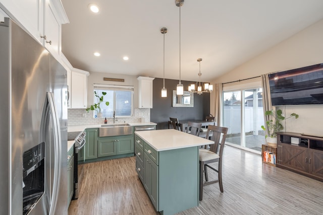 kitchen with green cabinetry, appliances with stainless steel finishes, a healthy amount of sunlight, white cabinetry, and a sink