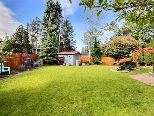 view of yard featuring a storage shed, an outdoor structure, and a fenced backyard