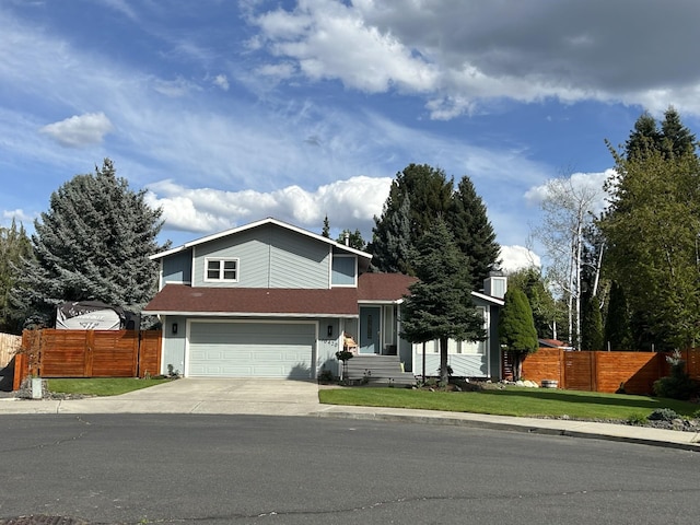 traditional home featuring driveway, a garage, fence, and a front yard