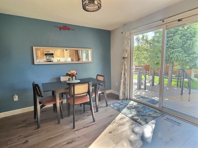 dining space featuring visible vents, baseboards, and wood finished floors