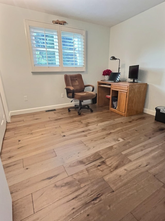 office space with visible vents, baseboards, and wood finished floors