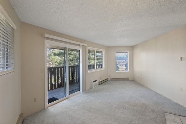 carpeted spare room with a textured ceiling and baseboard heating