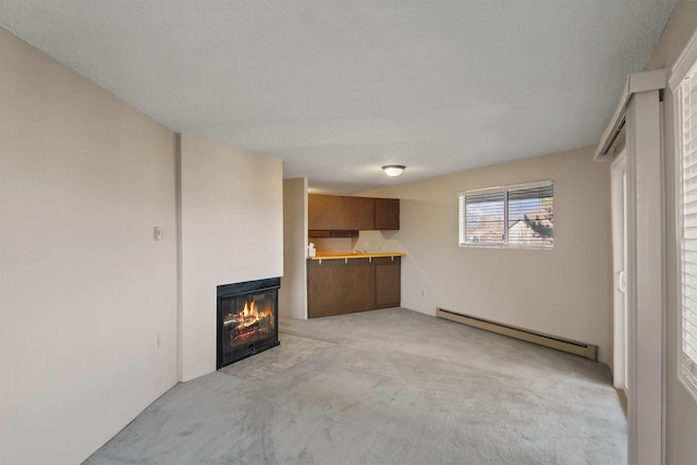 unfurnished living room with a fireplace with flush hearth, light colored carpet, a textured ceiling, and baseboard heating