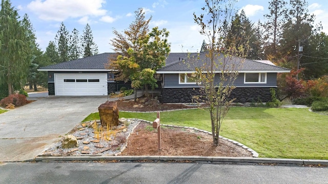 single story home with stone siding, an attached garage, a front lawn, and concrete driveway