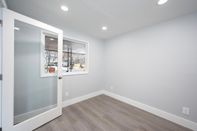 empty room with recessed lighting, baseboards, and wood finished floors