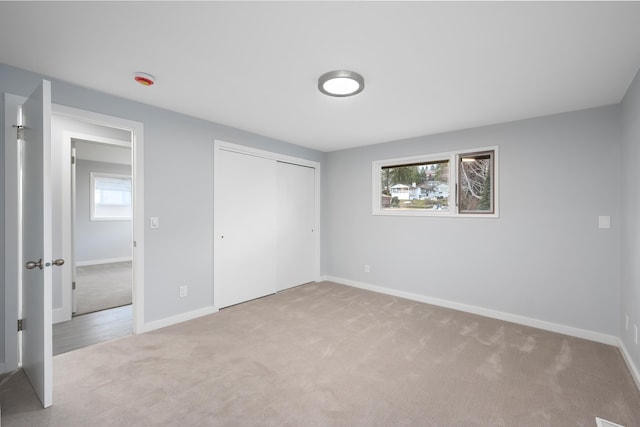 unfurnished bedroom featuring carpet, a closet, and baseboards