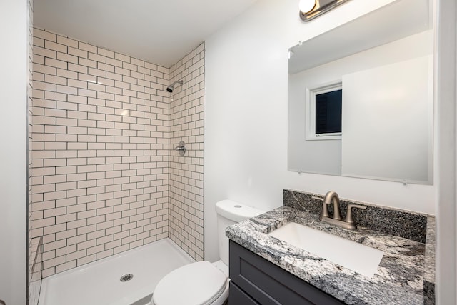 bathroom with toilet, a stall shower, and vanity