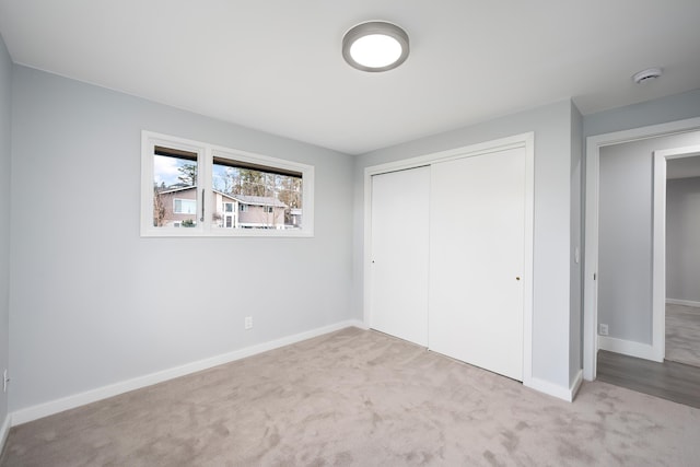 unfurnished bedroom featuring a closet, carpet flooring, and baseboards