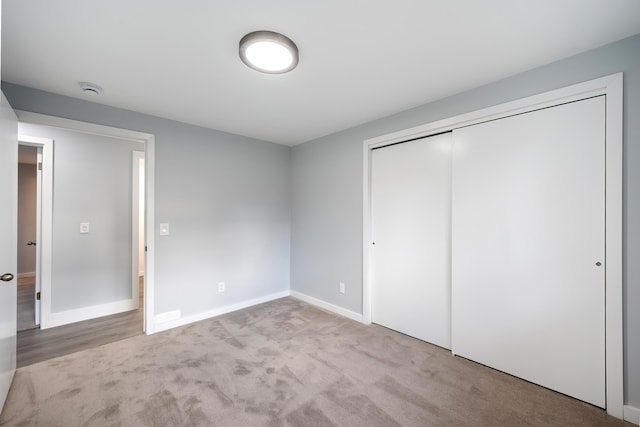 unfurnished bedroom featuring carpet floors, a closet, and baseboards