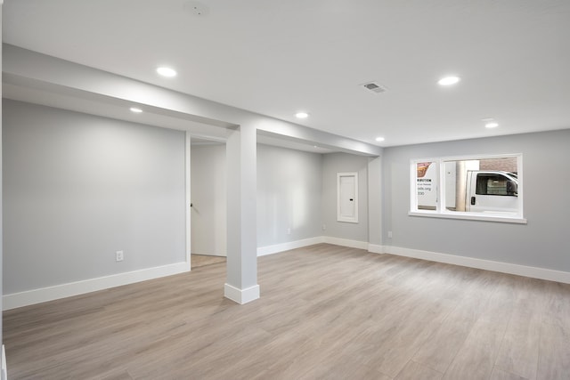 finished below grade area with baseboards, light wood finished floors, visible vents, and recessed lighting