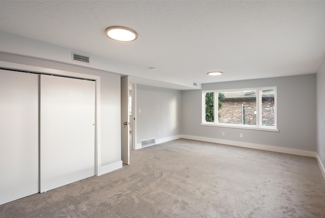 unfurnished bedroom featuring baseboards, carpet, visible vents, and a closet