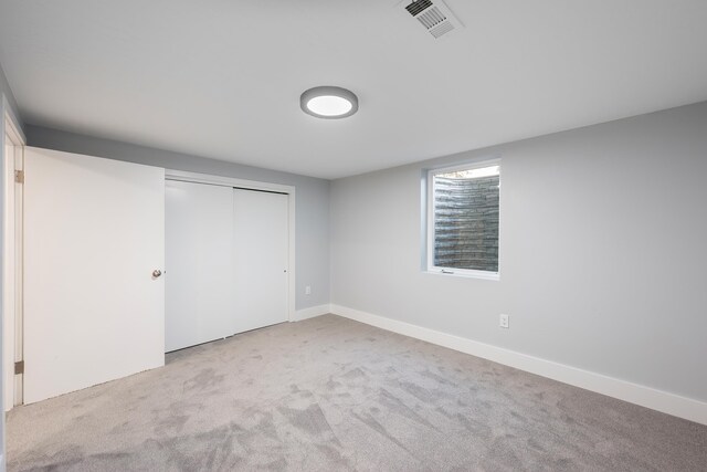 unfurnished bedroom with carpet floors, a closet, visible vents, and baseboards