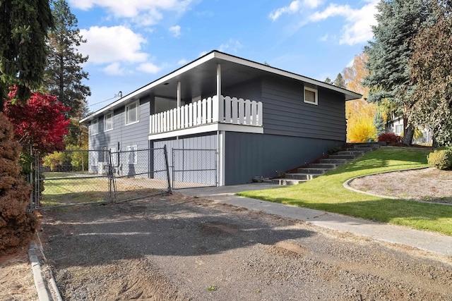 view of home's exterior with a yard, a gate, fence, and stairs