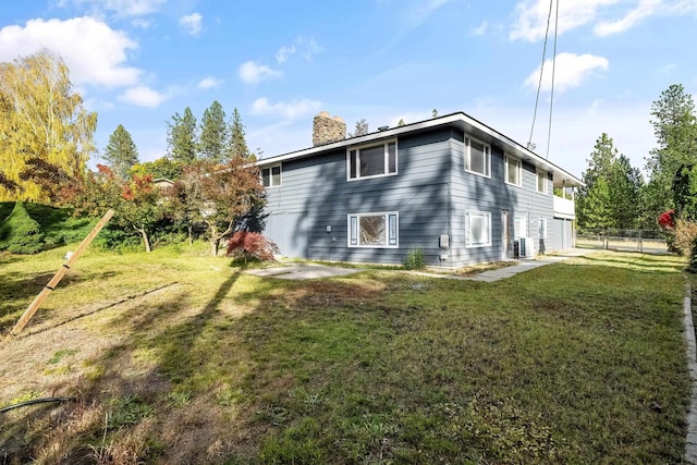 view of side of property featuring fence, a yard, a chimney, and central air condition unit