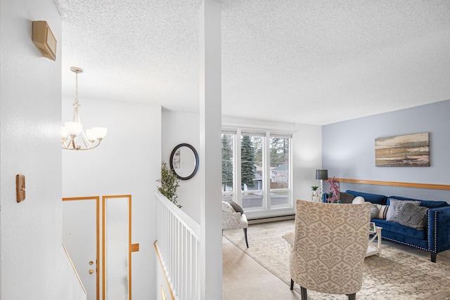 living area featuring a textured ceiling, baseboard heating, carpet flooring, and an inviting chandelier