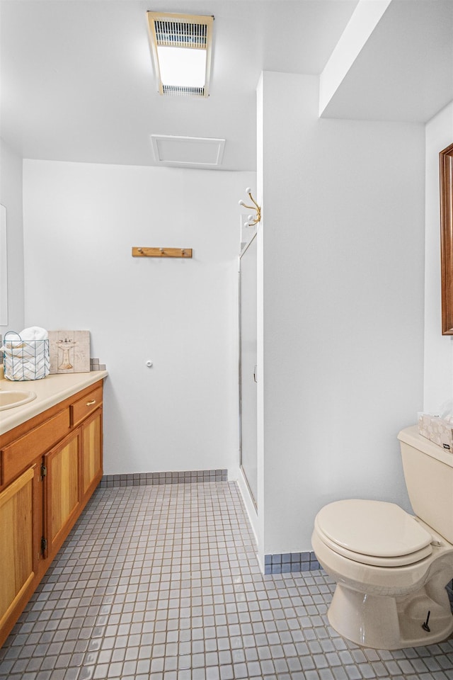 bathroom with toilet, a shower with shower door, vanity, visible vents, and baseboards