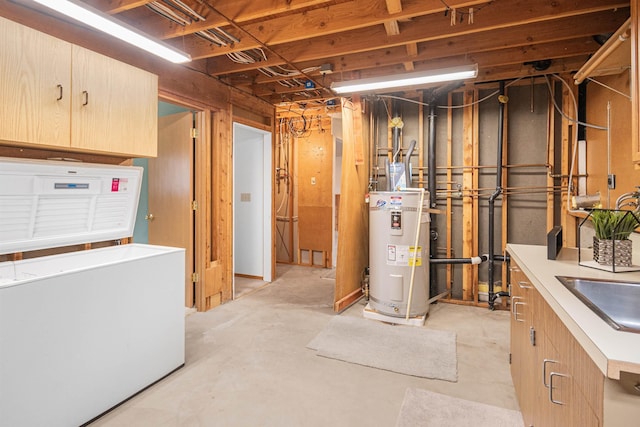 unfinished below grade area with water heater, a sink, and refrigerator