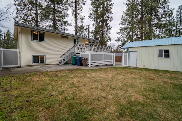 rear view of property with a patio area, fence, a wooden deck, and a lawn