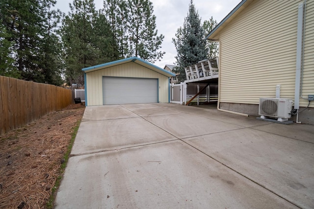 detached garage featuring ac unit and fence