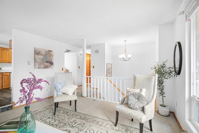 sitting room with light colored carpet, a textured ceiling, an upstairs landing, and an inviting chandelier