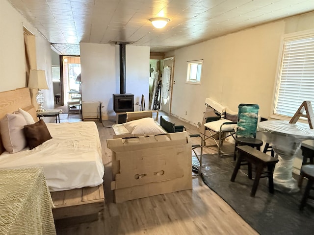 bedroom with wood finished floors and a wood stove