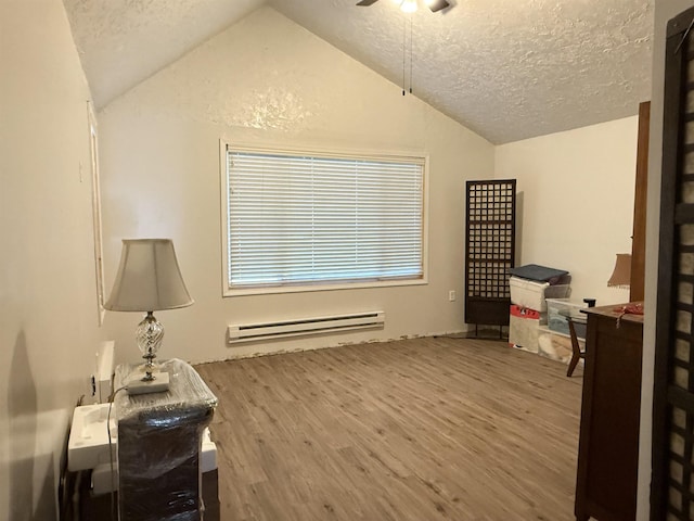 misc room with ceiling fan, a baseboard radiator, wood finished floors, vaulted ceiling, and a textured ceiling