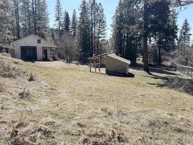 view of yard with fence and an outdoor structure