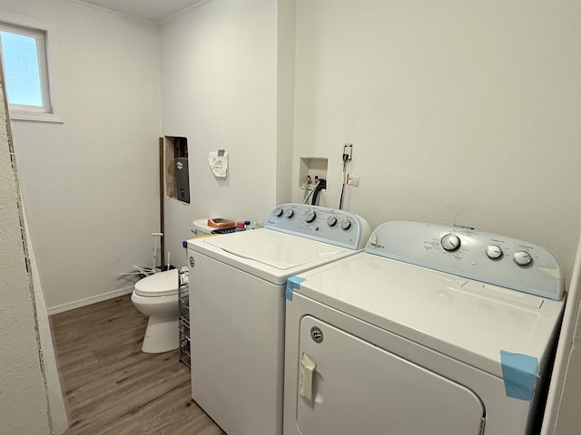 laundry room featuring laundry area, light wood-style flooring, baseboards, and separate washer and dryer