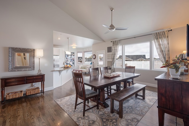 dining room featuring dark wood-style floors, ceiling fan, high vaulted ceiling, and baseboards