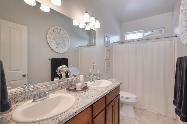 full bath featuring double vanity, tile patterned flooring, a sink, and toilet