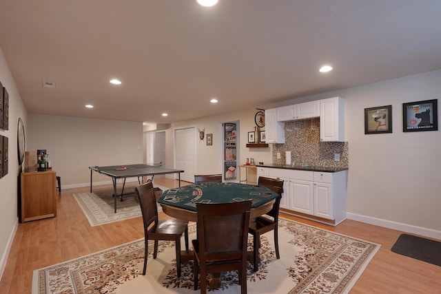 dining space featuring baseboards, light wood finished floors, and recessed lighting