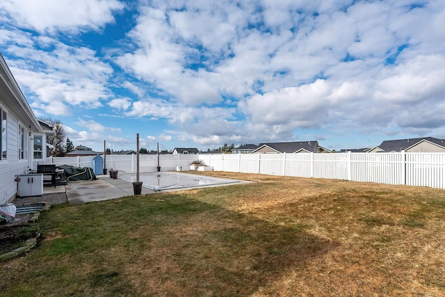 view of yard with a patio area, a fenced backyard, and an outbuilding