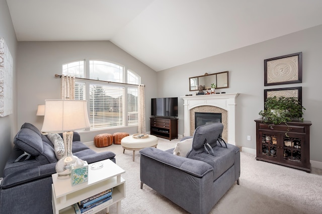 living area featuring lofted ceiling, baseboards, a glass covered fireplace, and light colored carpet