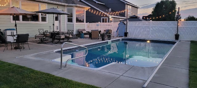 pool at dusk with a patio area, a fenced backyard, and a fenced in pool