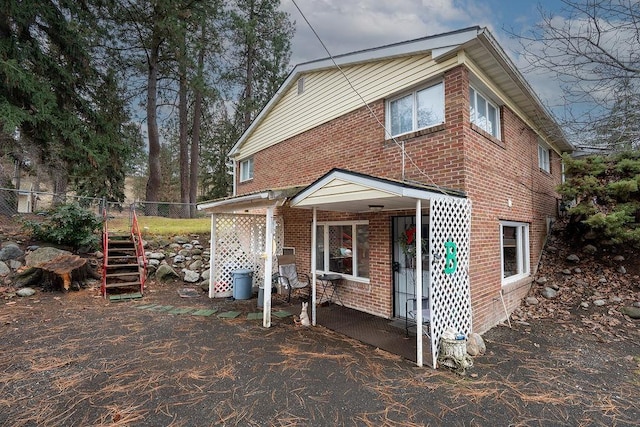 view of front of property featuring brick siding and fence