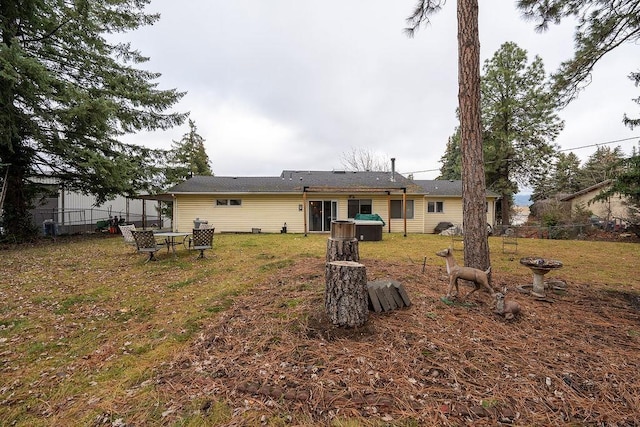 rear view of property featuring a yard and fence