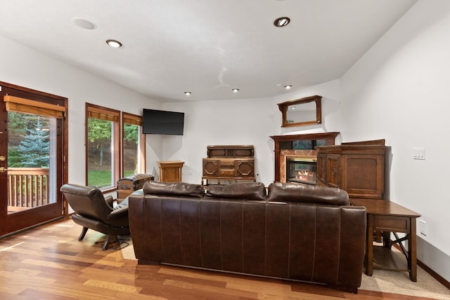 living room with baseboards, light wood finished floors, a premium fireplace, and recessed lighting