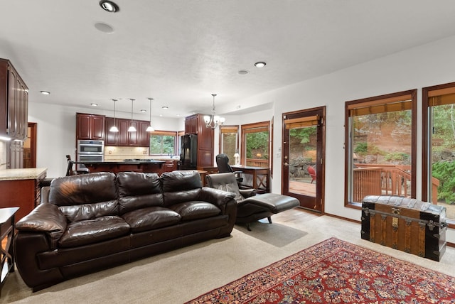 living room with light carpet, recessed lighting, and an inviting chandelier