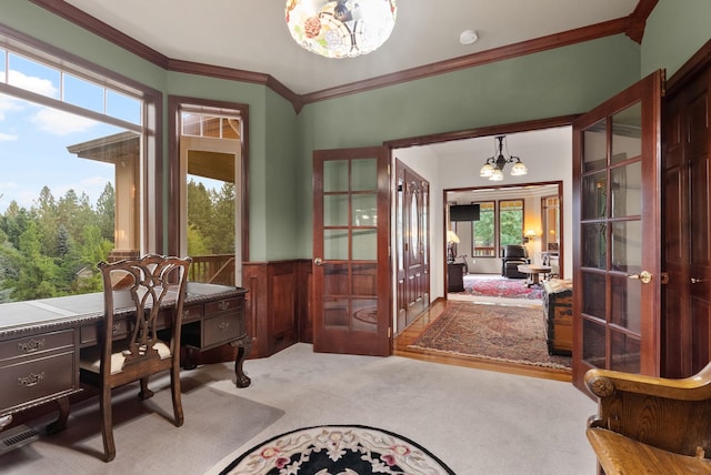 home office with a wainscoted wall, ornamental molding, french doors, carpet floors, and a notable chandelier